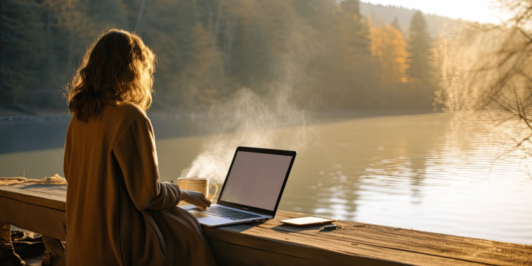 Een vrouw van 40+ met een laptop of notitieboek in de natuur of in een koffietentje – relaxed en in reflectie