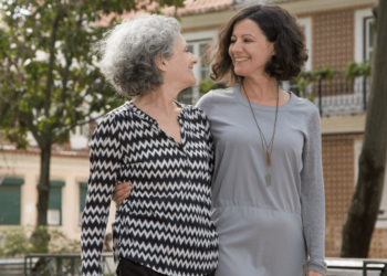 Een oudere vrouw die een jongere de hand vasthoudt